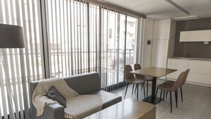 Ein modernes Wohnzimmer mit Sofa, Couchtisch und Essbereich mit Stühlen und Tisch.