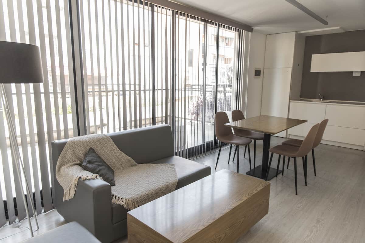 Una sala de estar moderna con un sofá, una mesa de centro y un comedor con sillas y una mesa.