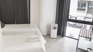 Ein Hotelzimmer mit zwei Betten, einem Fenster und einem Heizkörper.