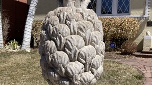 A stone sculpture of a pineapple on a pedestal in a garden area. - Elegant Garden-Level Apt, Beautiful Marble Spa Bath, City Center! 96 Walk Score! (Denver)