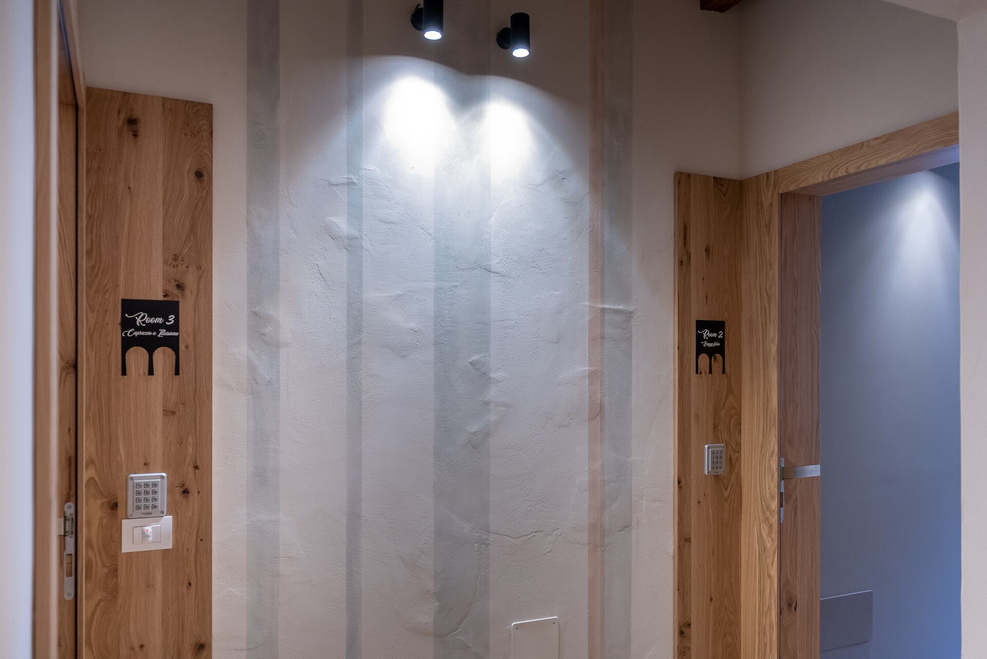 Un pasillo con puertas de madera que llevan las etiquetas 'Room 3' y 'Room 2'.