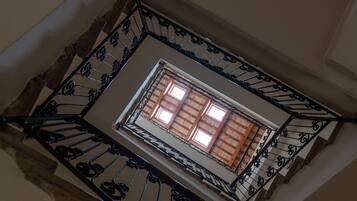 Un escalier en colimaçon orné de rampes noires et comportant une fenêtre en haut.