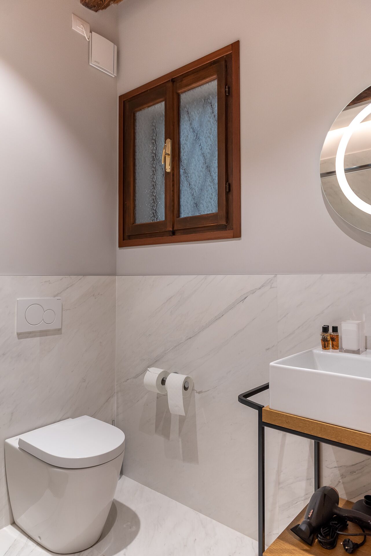 Une salle de bain moderne équipée de toilettes, d’un lavabo et d’un espace douche.