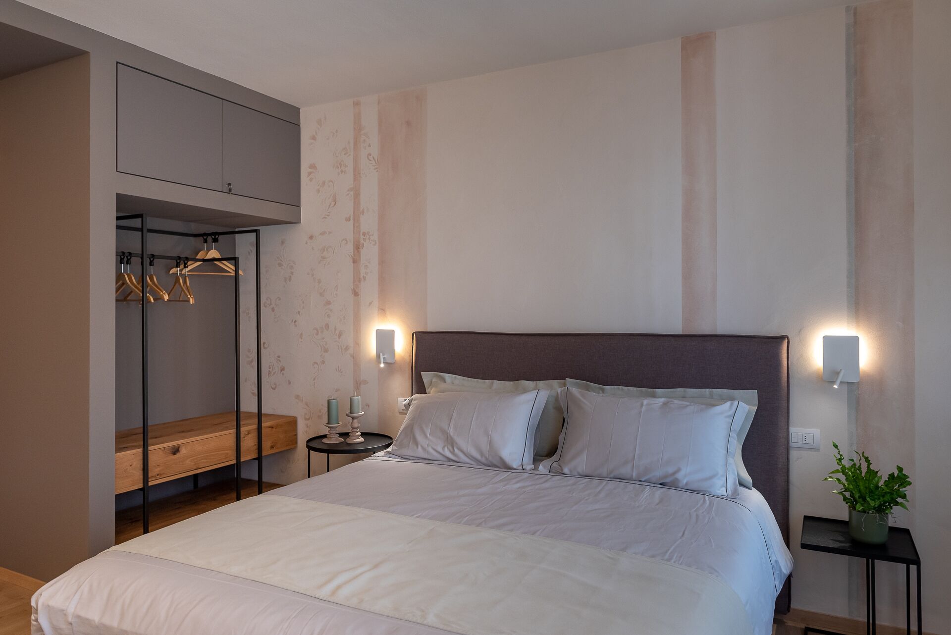 Une chambre bien rangée, avec un lit, des tables de chevet et une armoire.