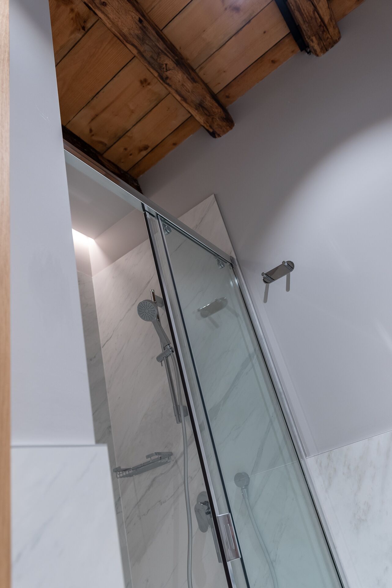 Une douche entièrementClose avec des parois en verre, un plafond en bois et des murs carrelés.