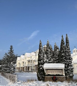 A snow-covered building with a sign reading 'The Beach House' at Lake Street. - The Savannah: 2BR + Loft Townhome Sleeps 8 | Pool, Hot Tub, Free Golf, Near Lake Michigan (Holland)