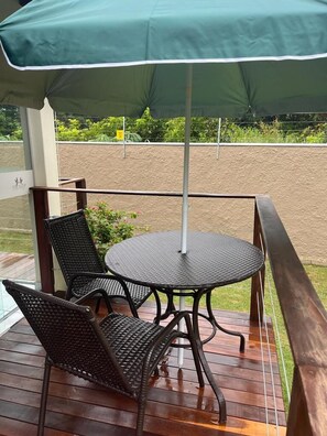 A covered outdoor seating area with a table and two chairs. - POUSADA ACONCHEGO MT (Chapada dos Guimarães)