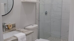Un bany modern amb vàter, rentapel i plat de dutxa.