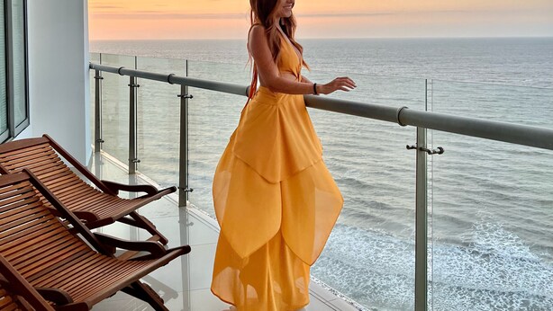 A balcony with a railing, wooden chairs, and a view of the sea at sunset. - Apartamento frente al mar Cartagena (Cartagena)