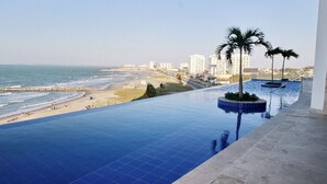 A pool with a view of the beach and ocean, surrounded by buildings. - Apartamento frente al mar Cartagena (Cartagena)