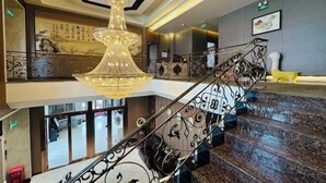 A grand staircase with ornate metal railings and a large chandelier. - Greater Khingan Tahe Chengxin Business Hotel (Tahe)