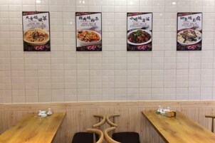 Un interior de restaurante con paredes de azulejos y mesas de madera.
