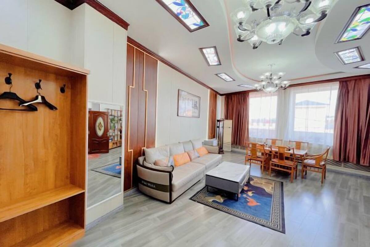 Una sala moderna con un sofá, una mesa de centro y un comedor con sillas.