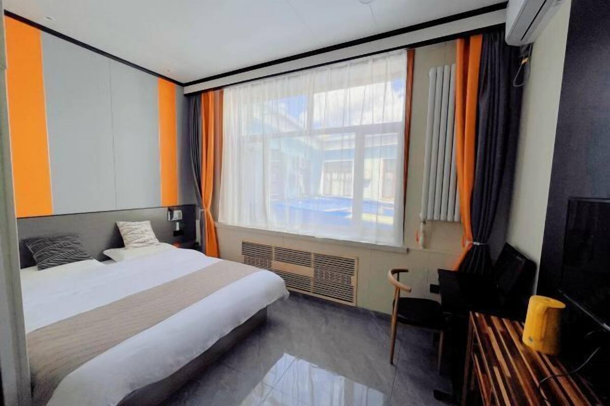 Una habitación de hotel moderna con una cama grande, un escritorio y una silla.