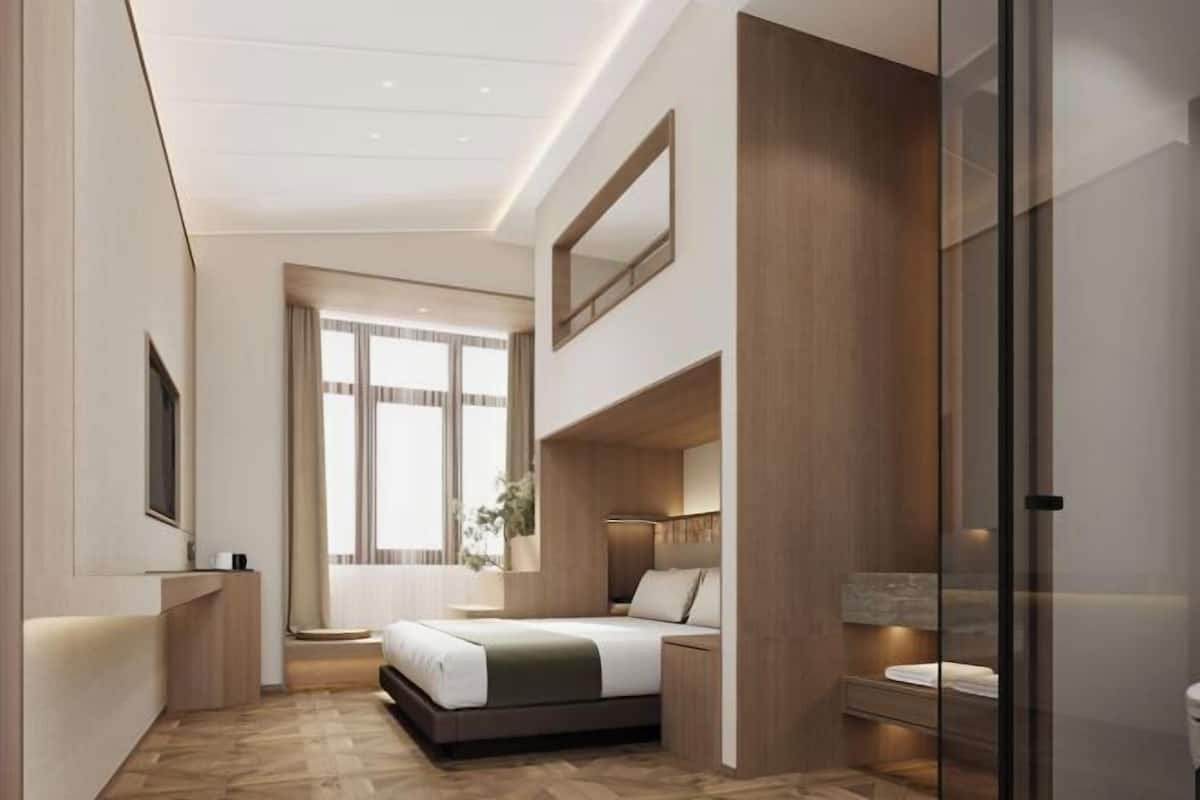 Un dormitorio moderno con cama, mesita de noche y un ventanal grande.