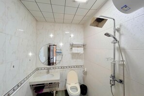 A bathroom with a toilet, sink, mirror, and shower. - Greater Khingan Tahe Chengxin Business Hotel (Tahe)