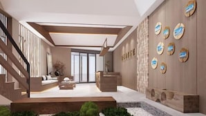 A modern interior with a reception desk, seating area, and a staircase. - Greater Khingan Tahe Chengxin Business Hotel (Tahe)