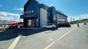A modern hotel with a prominent entrance and a clear sky. - Greater Khingan Tahe Chengxin Business Hotel (Tahe)