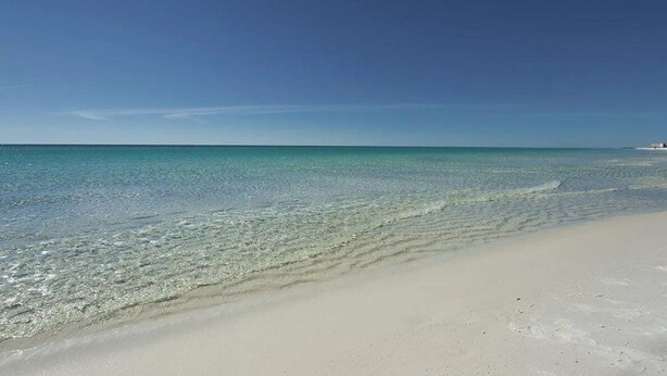 A beach with clear turquoise water and a sandy shore. - Villa De Palmas 5 Bedroom Home by RedAwning (Destin)