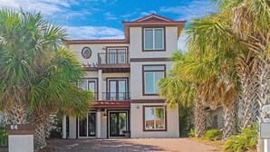 A multi-story building with a symmetrical facade, large windows, and a central entrance. - Villa De Palmas 5 Bedroom Home by RedAwning (Destin)