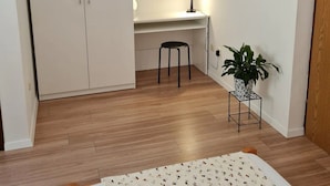 A bedroom with a bed, a desk, a chair, a wardrobe, a round mirror, and a potted plant. - Apartment Stella (Zupa dubrovacka)
