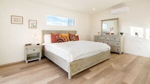A bedroom with a wooden bed, a dresser, a nightstand, and a window. - Sun Oro Joshua Tree - Hot Tub, Bbq, Fire Pit & Gameroom 2 Bedroom Home by RedAwning (Joshua Tree)