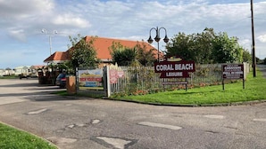 A sign for Coral Beach Leisure with a reception and sales office. - Caravan for Rent Coral Beach R2v7 Ingoldmells (Skegness)