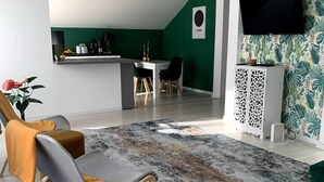 A modern living room with a grey sofa, a patterned rug, and a green accent wall. - Spacious 3 Bed Apartment Cluj Floresti Near Vivo (Floresti)