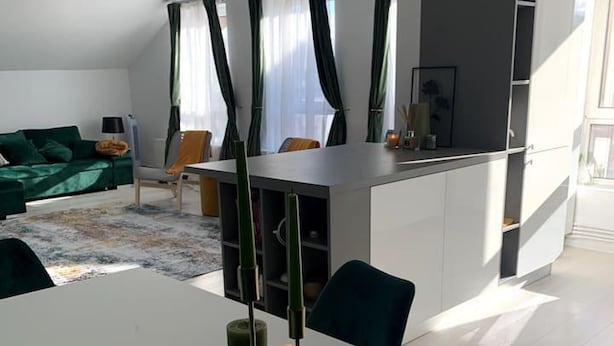A modern living room with a dining area, green curtains, and a white table. - Spacious 3 Bed Apartment Cluj Floresti Near Vivo (Floresti)