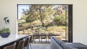 Una cocina moderna con comedor, sofá y vistas a un paisaje natural.