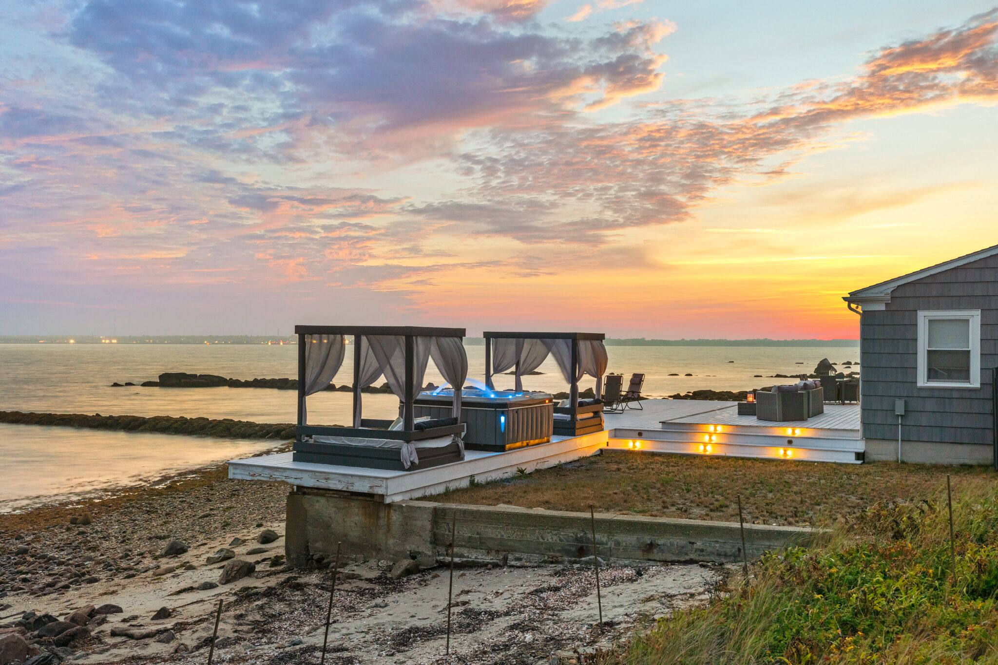 Waterfront Oasis with day beds and hot tub with captivating sunsets.