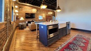 A modern kitchen with a central island, built-in appliances, and a large window. - 1882 Lofts - 402-Downtown 2nd & Church (Nashville)