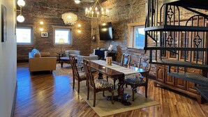 A rustic dining area with a wooden table, chairs, and a chandelier. - 1882 Lofts - 402-Downtown 2nd & Church (Nashville)