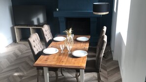A dining area with a wooden table, four chairs, and a decorative centerpiece. - Renovated house with garage and 300 M2 of land,  (Condé-sur-Sarthe)