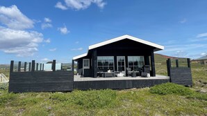 A modern house with a large deck, large windows, and a flat roof. - A cozy cottage with a sauna in the Golden Circle area. HG-00016818  Id 3221494 (Grímsnes- og Grafningshreppur)