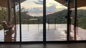 Área externa coberta com um banco e vista para uma paisagem montanhosa.