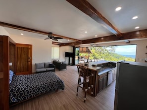 Ein geräumiges Zimmer mit Bett, Sofa, Essbereich und Küche.