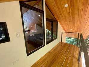 Un intérieur moderne avec un plafond en bois, de grandes fenêtres et une vue sur la verdure environnante.