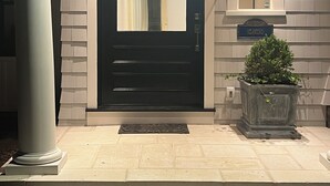 A black door with a glass panel, a potted plant, and a sign reading "SEAWIND".