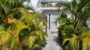 A pathway leading to a building with a white facade and a door labeled "Morro." - MOOREA Exceptional view of the Caribbean Sea, Swimming pool (Collectivité de Saint-Martin)