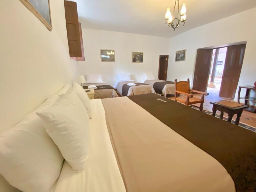 Een hotelkamer met een groot bed, twee nachtkastjes, een stoel en een klein tafeltje.
