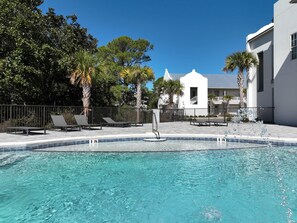 Relax by the serene pool surrounded by lush gardens and lounge chairs.