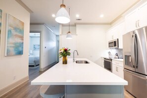 Enjoy cooking in this well-equipped kitchen with a central island, sink, and stainless steel appliances.