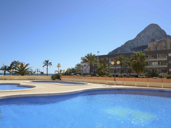 A swimming pool area with a mountain in the background.