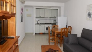 A compact living space with a kitchenette, a dining area, and a seating area.