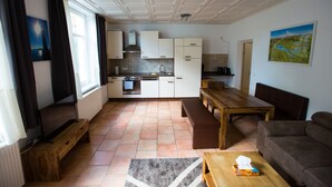 Una cocina moderna con armarios blancos, una mesa de comedor de madera y un banco.