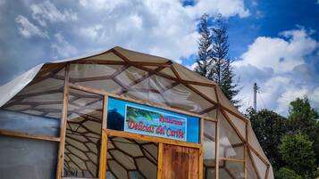 Une serre avec une enseigne indiquant : « Restaurante Delicias del Caribe ».