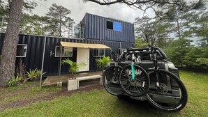 A modern house with a black exterior, a small porch, and a bicycle parked in front.