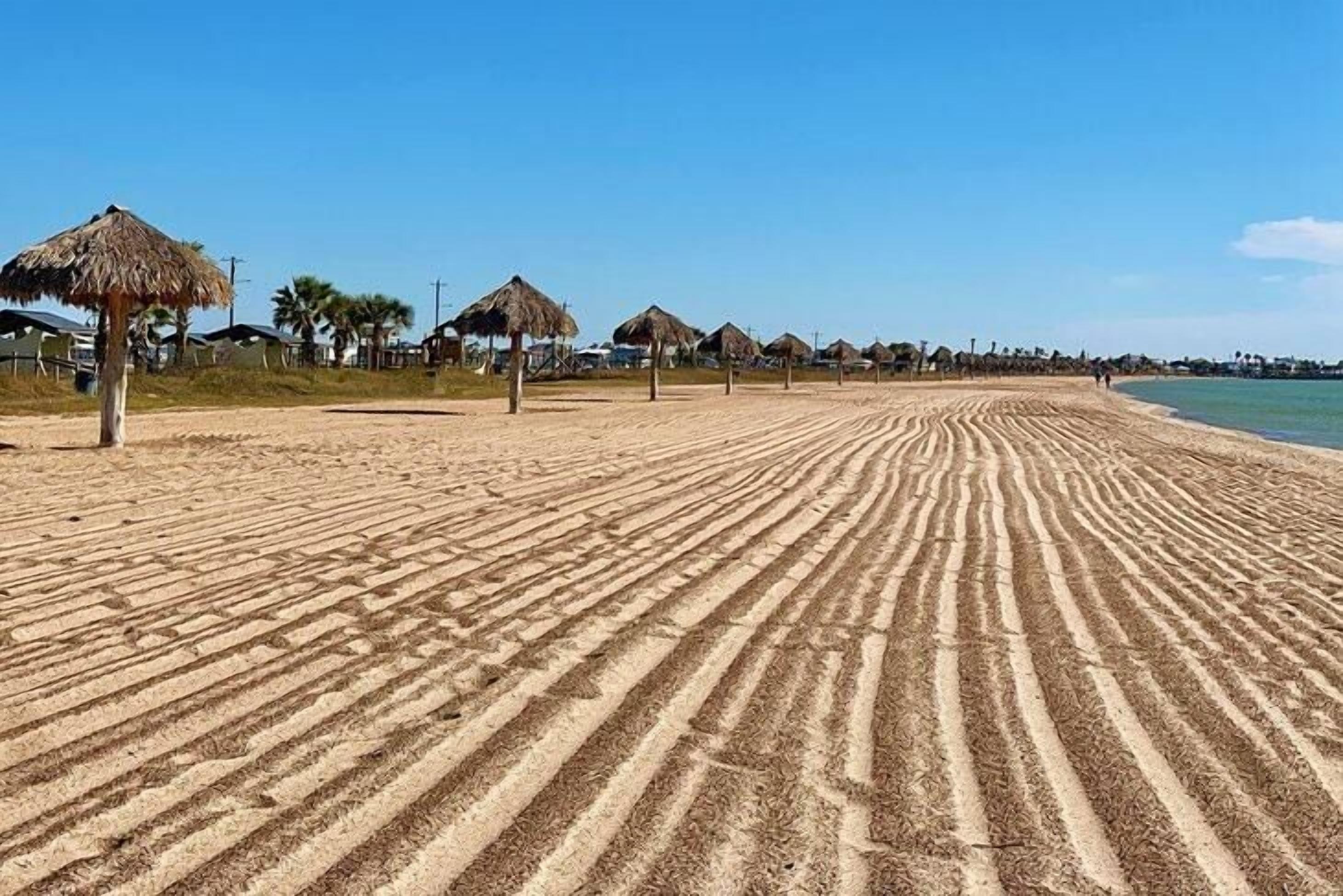 Uma praia com palafitas e uma faixa de areia.