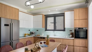 Een moderne keuken met houten kastjes, roestvrijstalen apparatuur en een centraal eiland met zitplaatsen.